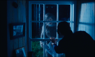 Woman looking a bigfoot from a window